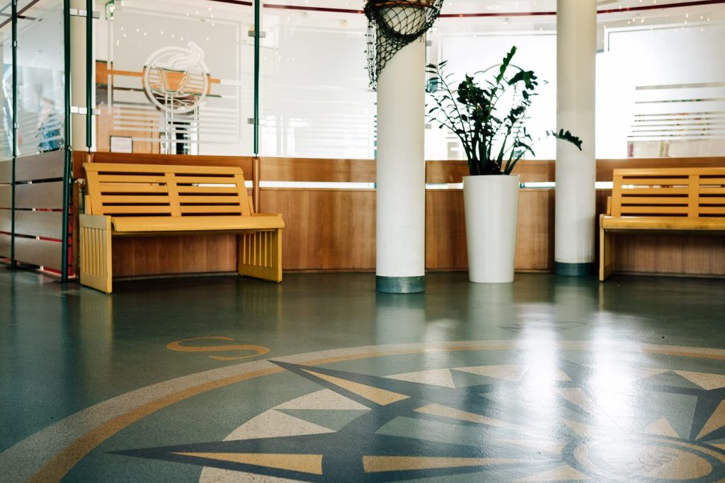 Lobby der Klinik mit Windrose als Bodengestaltung Holzbänken.