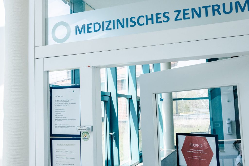 Der Eingang zum Medizinischen Zentrum im Innenbereich der Eltern-Kind-Klinik, über der Glastüre steht Medizinisches Zentrum.