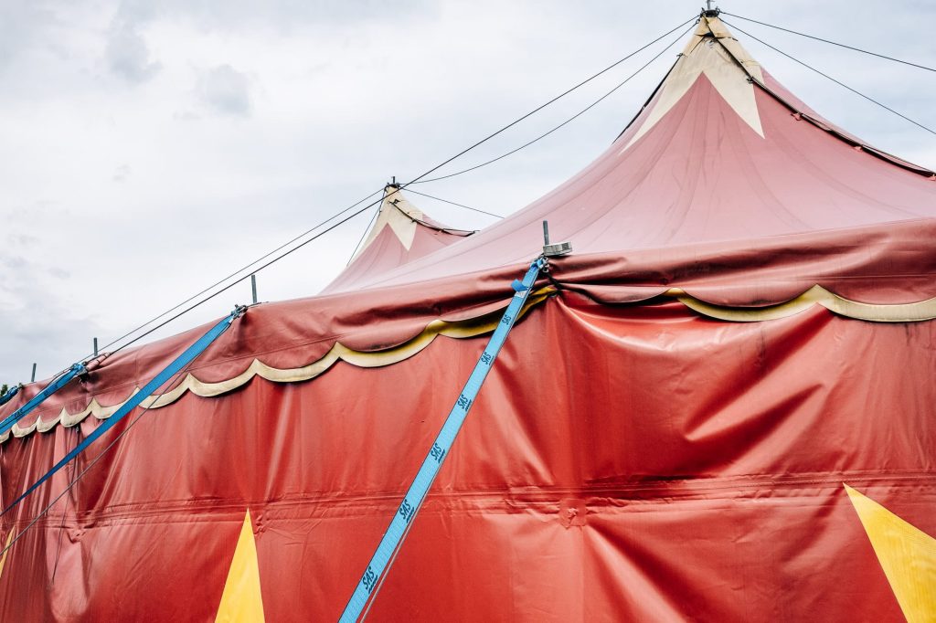 Der Ausschnitt eines roten Zirkuszeltes mit gelben Sternen.