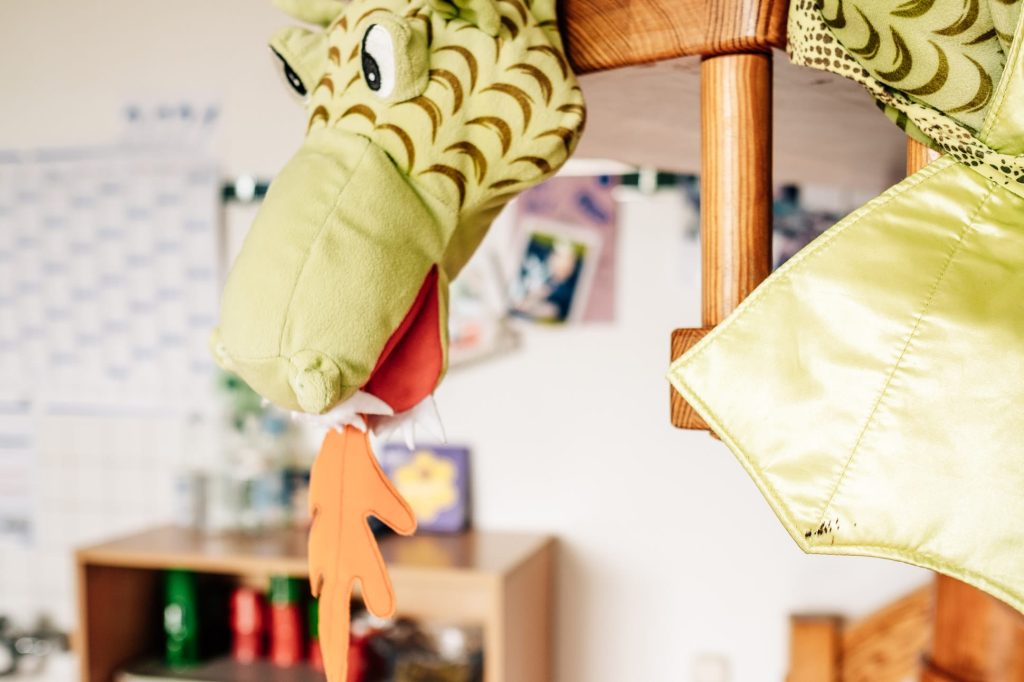 Ein Stoffdrache ragt von rechts ins Bild und speit Feuer.