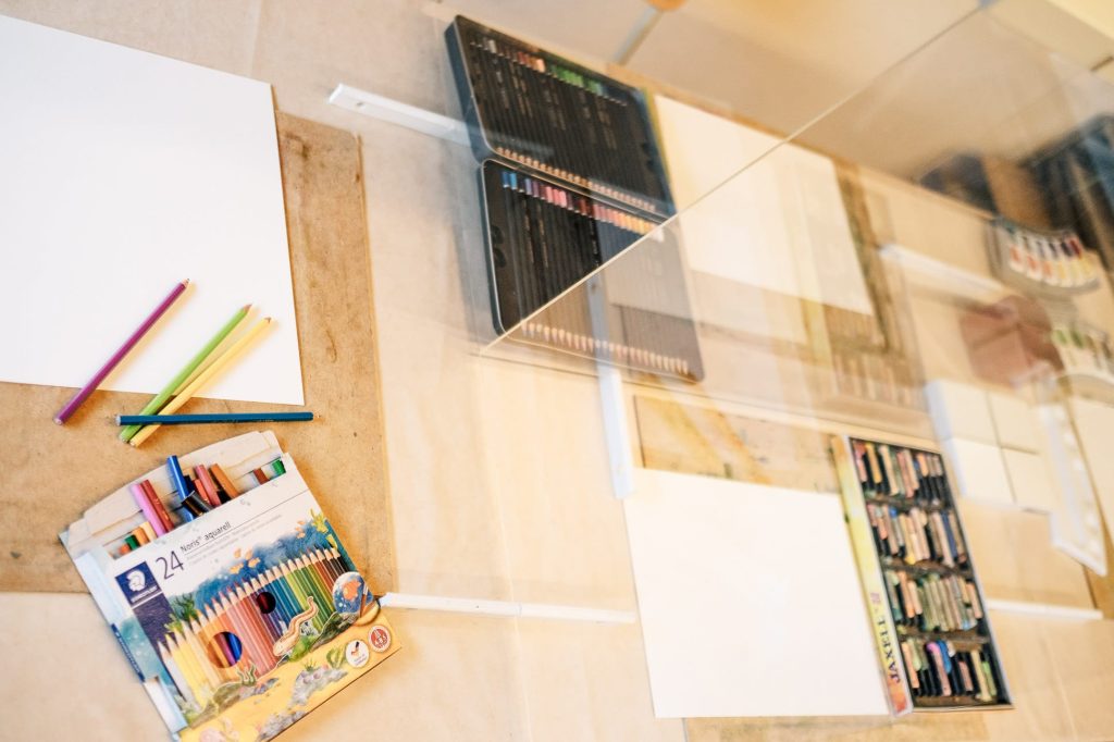 Unterschiedliche Malutensilien auf einem Tisch.